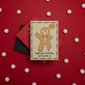 Greeting card with gingerbread man design on a red background with white polka dots